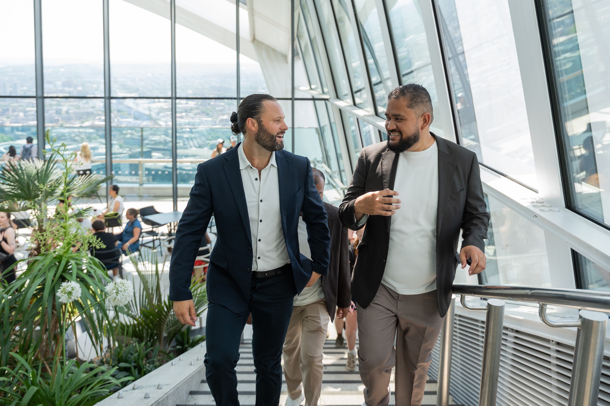 Senior technology executives in conversation inside a modern glass building
